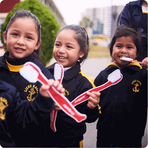 three smiling kids with dummy toothbrushes